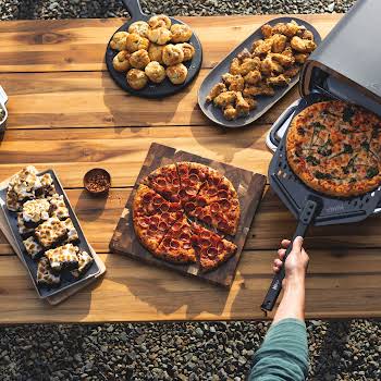 R_MO201UK_InUse_BackYard_OnTable_Wings_Desert_Casserole_RemovingPizza_Man