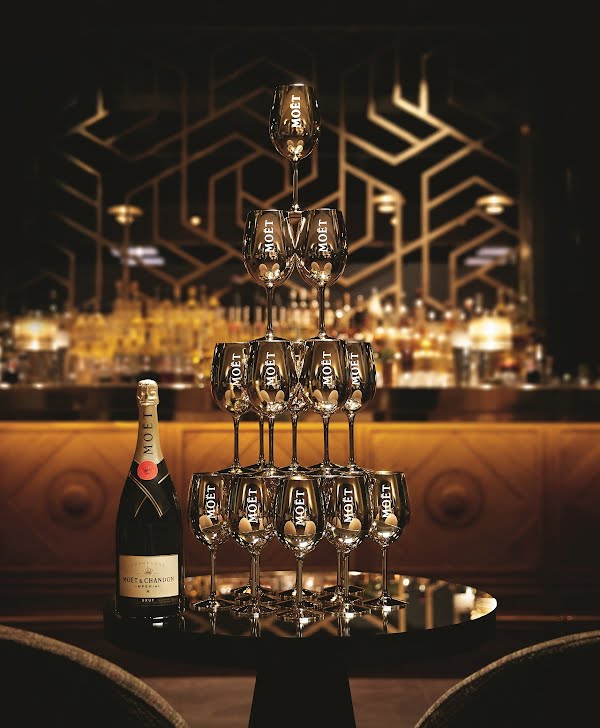 moet & chandon champagne beside gold goblets