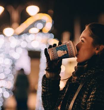 woman alone at Christmas drinking hot chocolate in the cold