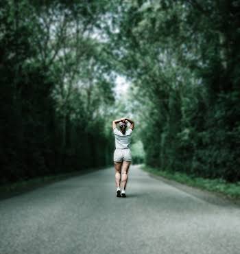 woman running on tree-lined street alone