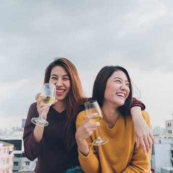 Happy asia girl friends enjoy laughing and cheerful sparkling wine glass at rooftop party,Holiday celebration festive,teeage lifestyle,freedom and fun.lesbian couple.