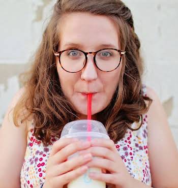 Woman sipping through plastic straw, ahead of ban