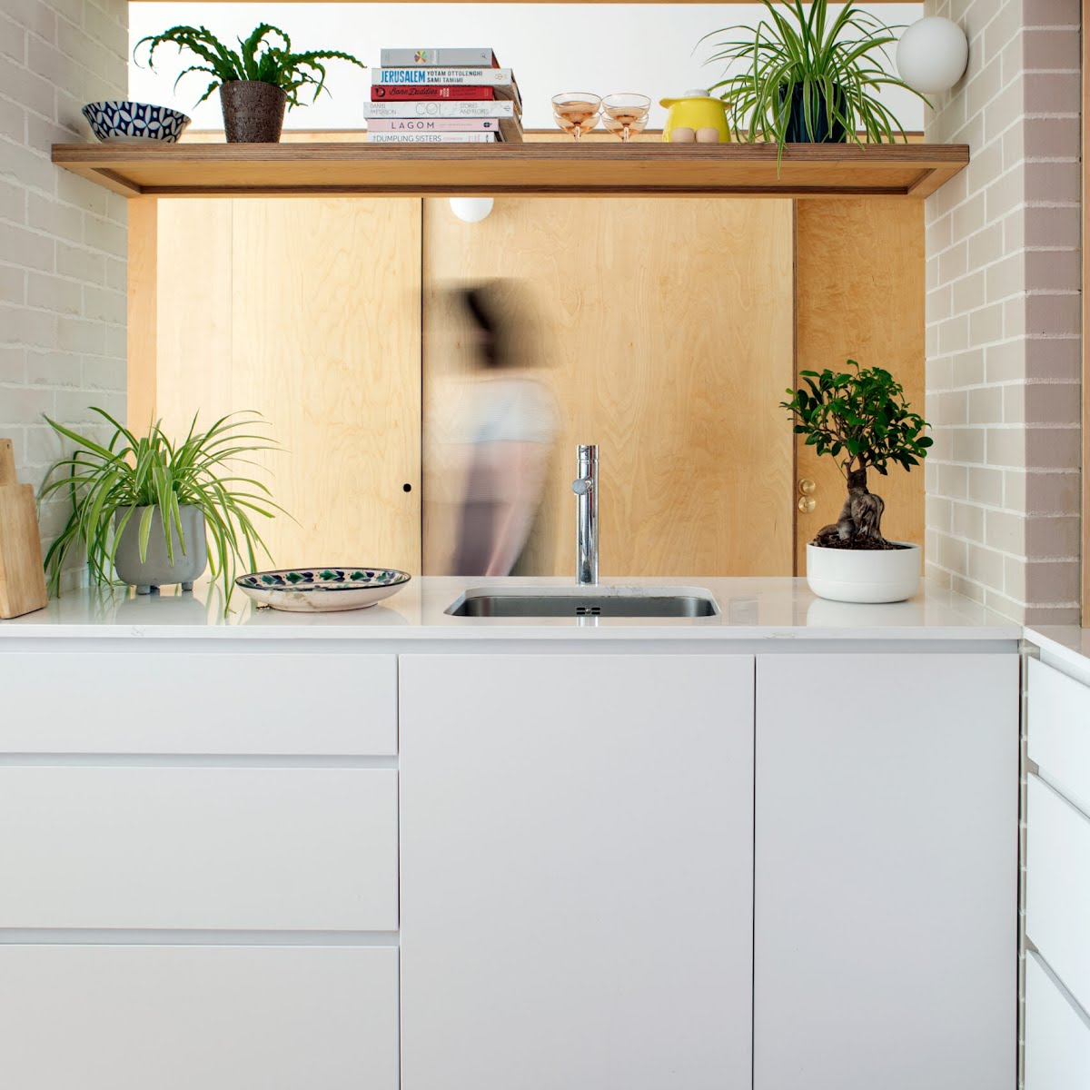 A plaster wall was taken down to create this worktop and sink area, with open shelving above. “It still works to divide the room, but it doesn’t feel so closed in.”