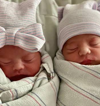 two newborn twins sleeping beside each other