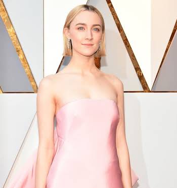 woman with short blonde hair wearing a light pink dress