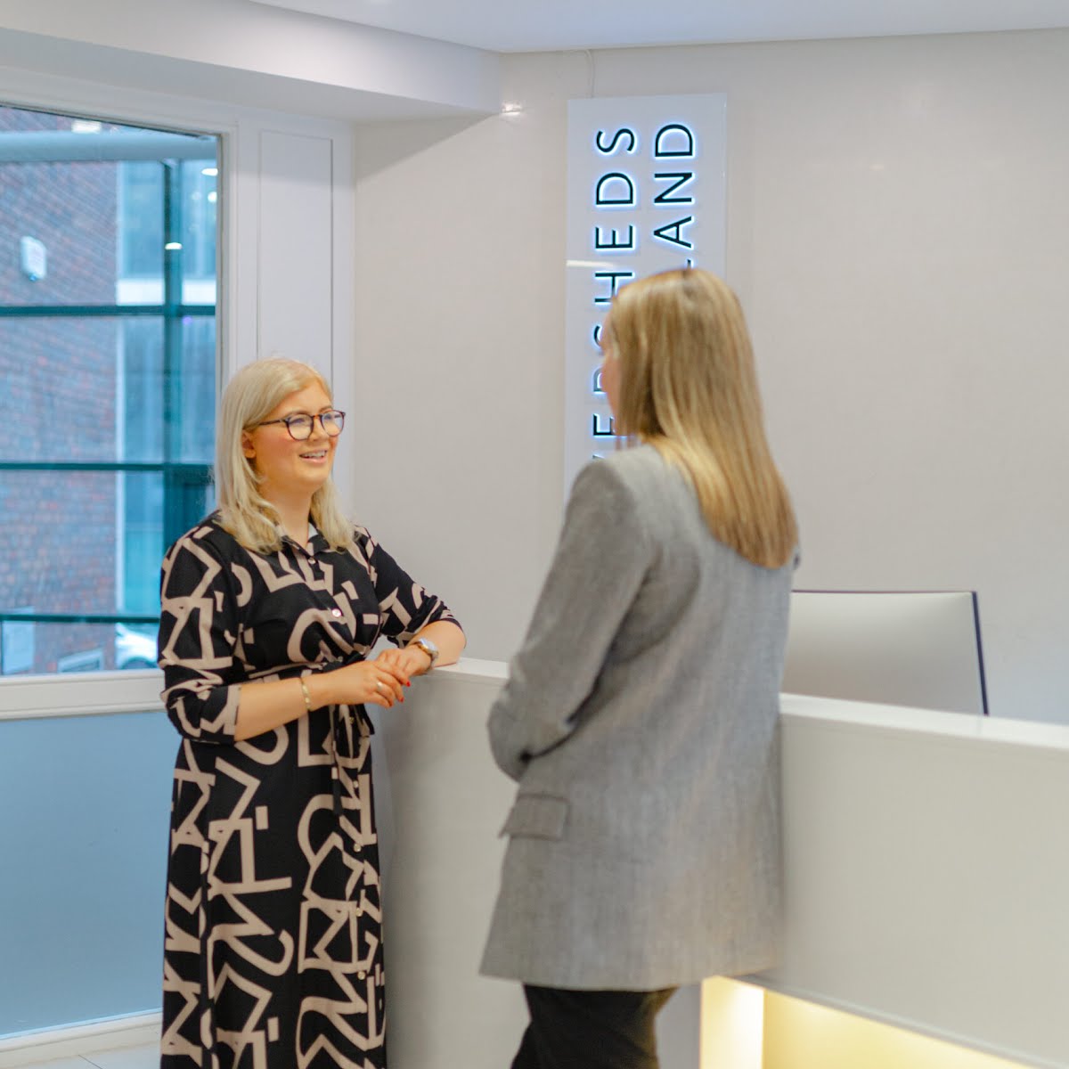 Niamh Donnelly talks to a co-worker at the Eversheds Sutherlands office.