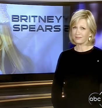 woman standing in front of TV screen with Britney Spears on it