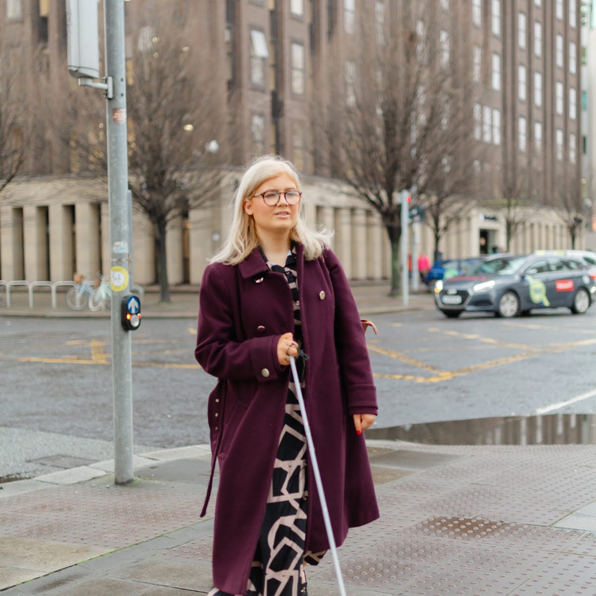 Niamh Donnelly uses her symbol cane as she walks down the road.