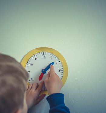 Child changing the hands on a clock